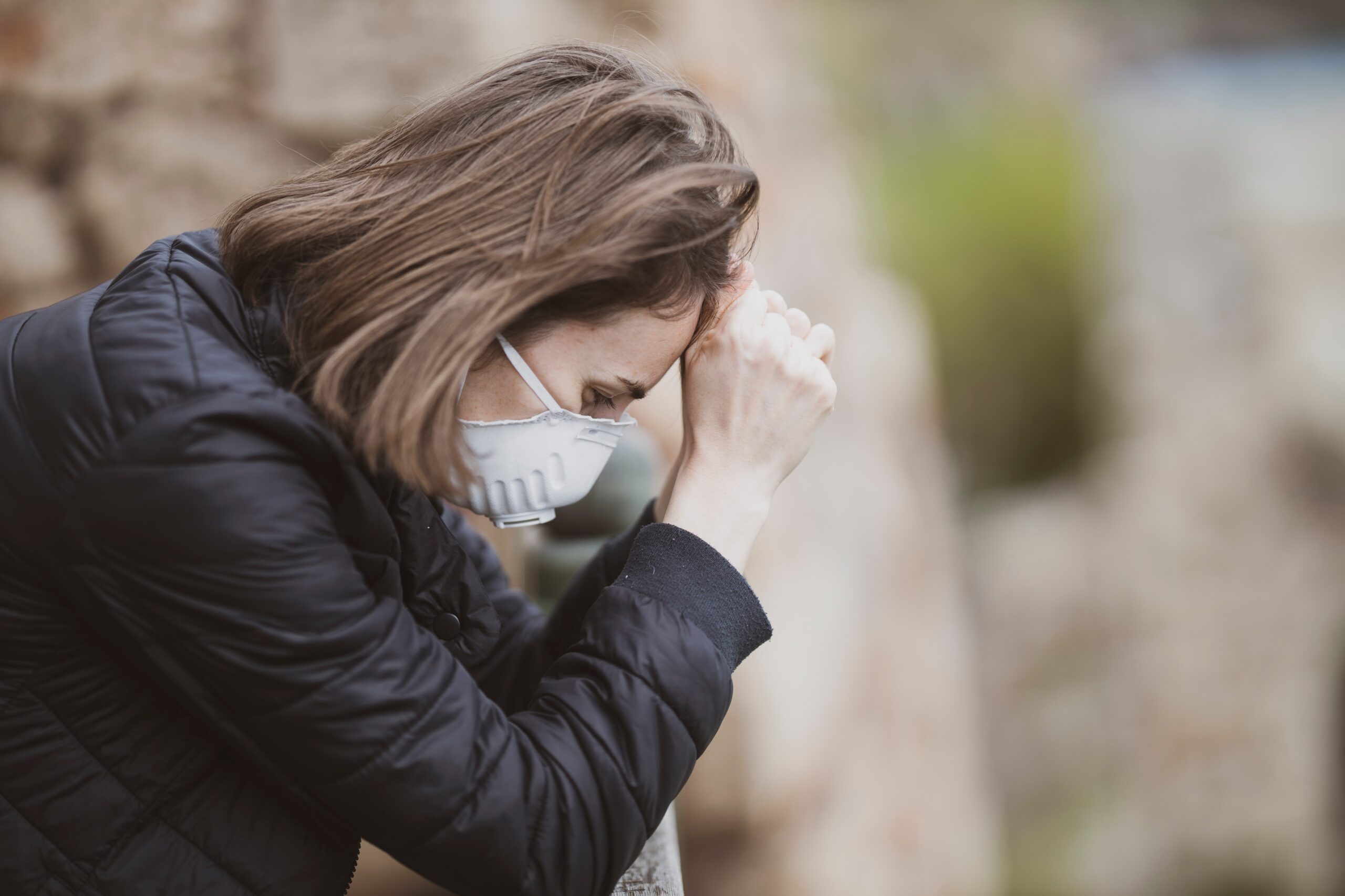 woman wearing medical mask is praying